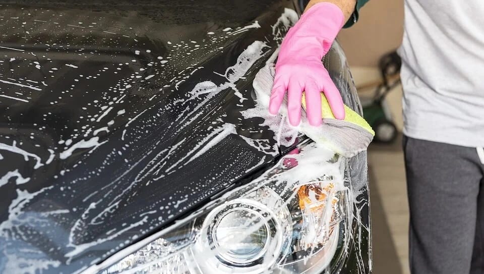 a student washing a car